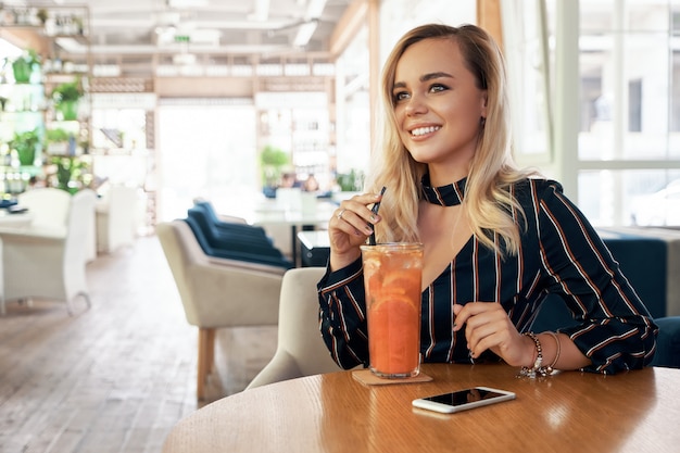 Mooie vrouw die een cocktail drinkt