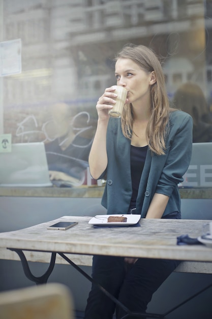 Mooie vrouw die een koffie in de stad heeft