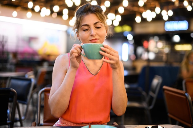 Mooie vrouw die een koffie in een koffie heeft