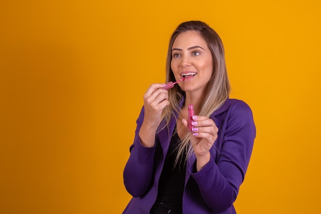 Mooie vrouw die een lipgloss op haar mond zet vrouw die lipgloss aanbrengt