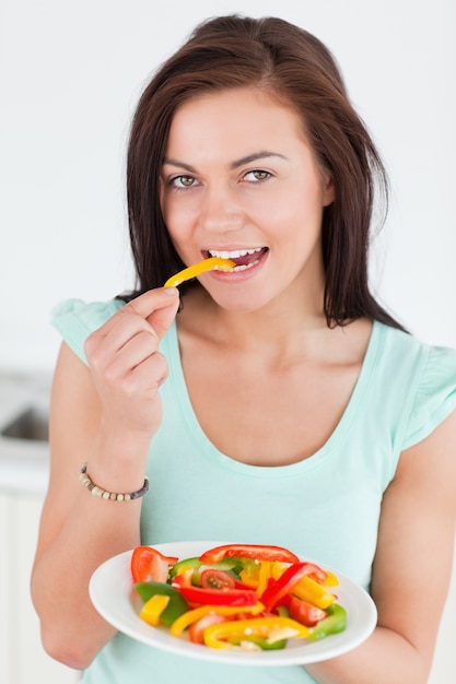 Mooie vrouw die een salade eet