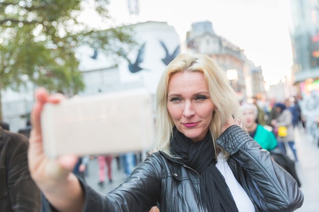 Foto mooie vrouw die een selfie in londen neemt