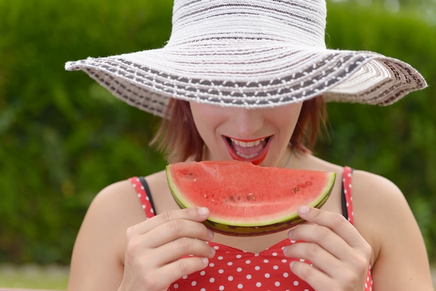 Mooie vrouw die een watermeloen eet