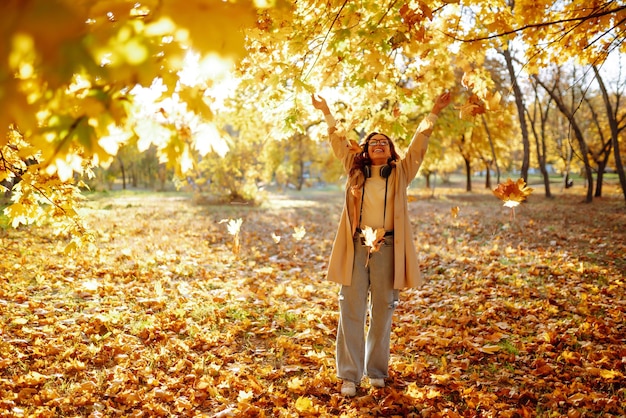 Mooie vrouw die foto's maakt in het herfstbos Vrouw die geniet van het herfstweer Lifestyle-concept