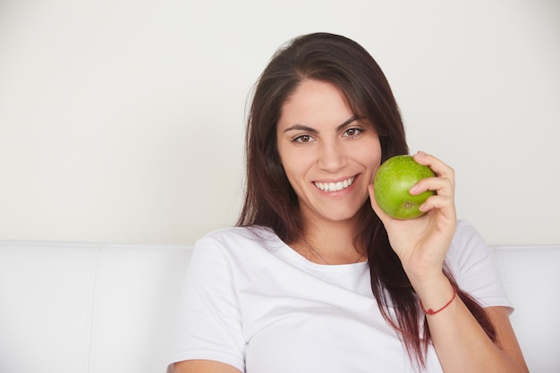 Mooie vrouw die groene appel houdt