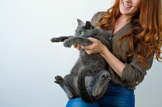 Mooie vrouw die haar Russische blauwe kat in handen houdt