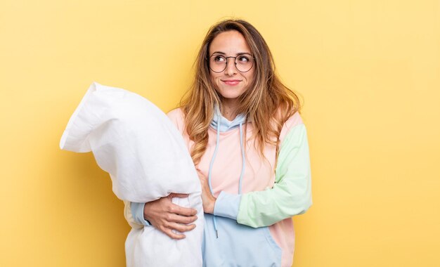 Mooie vrouw die haar schouders ophaalt, zich verward en onzeker voelt. pyjama concept