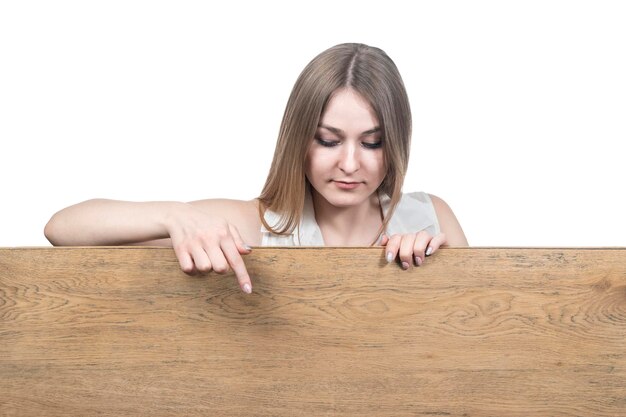 mooie vrouw die haar vinger naar beneden wijst op een houten bord geïsoleerd op een witte achtergrond