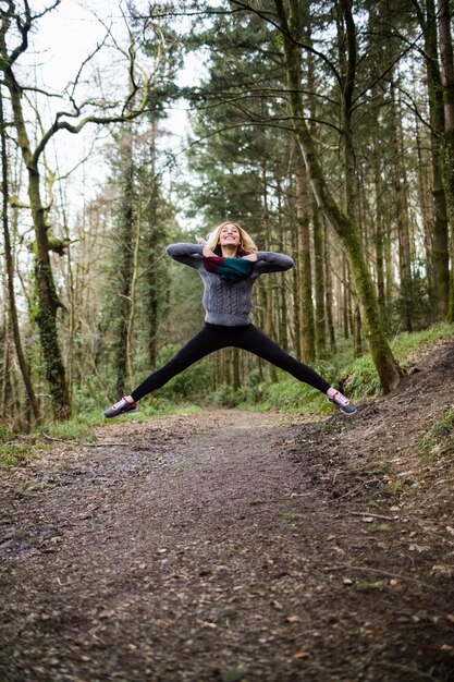 Mooie vrouw die in bos springt