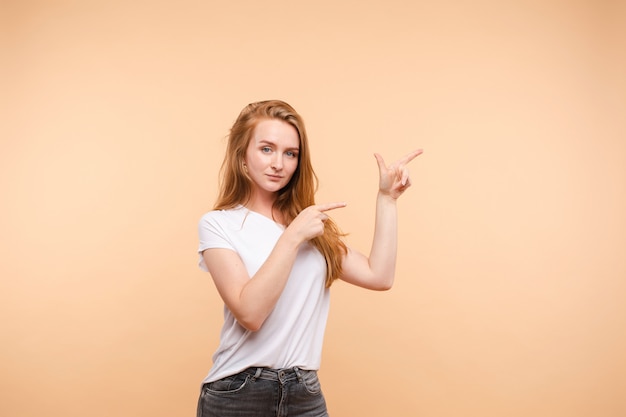 Mooie vrouw die in vrijetijdskleding met haar vingers richt