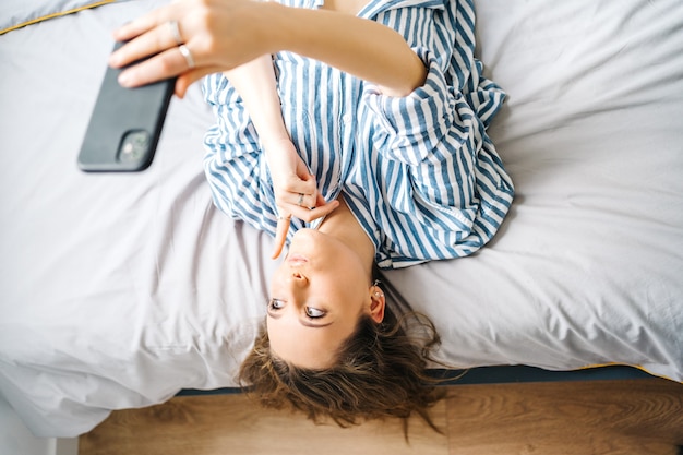 Foto mooie vrouw die inhoud maakt voor sociale media influencer in slaapkamer ontspannen met videochat