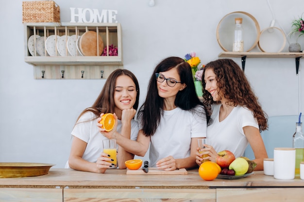 Mooie vrouw die jus d'orange voor haar kinderen maakt