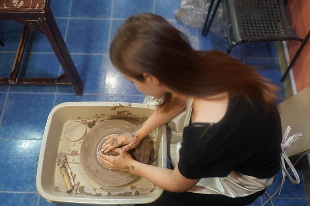 Foto mooie vrouw die keramisch aardewerk maakt op wielhanden close-up vrouw in freelance zakelijke hobby