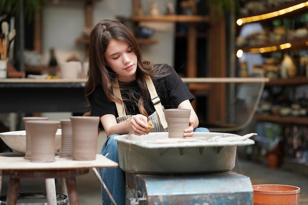 Mooie vrouw die keramisch aardewerk maakt op wielhanden close-up vrouw in freelance zakelijke hobby