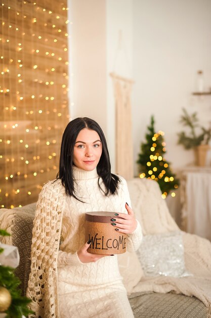 Mooie vrouw die Kerstmis thuis viert