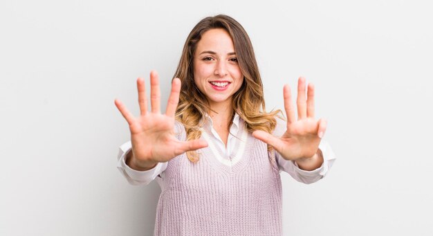 Mooie vrouw die lacht en er vriendelijk uitziet en nummer negen of negende toont met de hand vooruit die aftelt