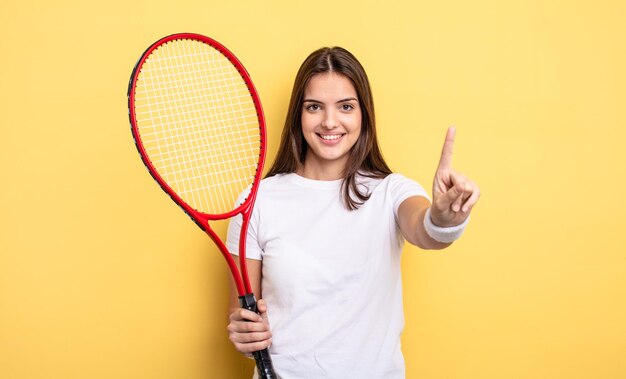 Mooie vrouw die lacht en er vriendelijk uitziet, met nummer één. tennisser concept