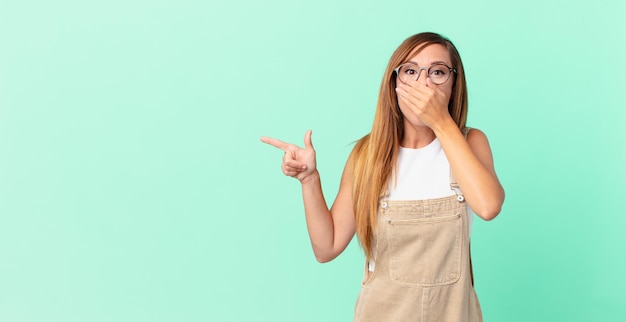 Mooie vrouw die mond bedekt met handen met een geschokte en een kopieerruimte