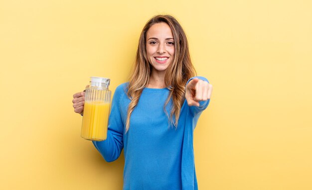 Mooie vrouw die naar de camera wijst en je sinaasappelsapconcept kiest