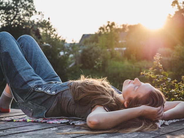 Mooie vrouw die op een houten terras ligt