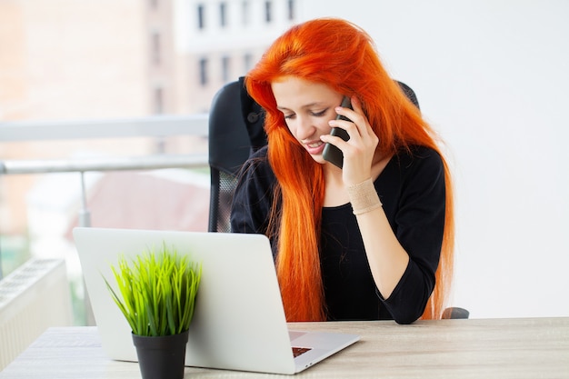 Mooie vrouw die op laptop op kantoor werkt.