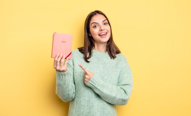 Mooie vrouw die opgewonden en verrast kijkt en naar de zijkant wijst. planner concept