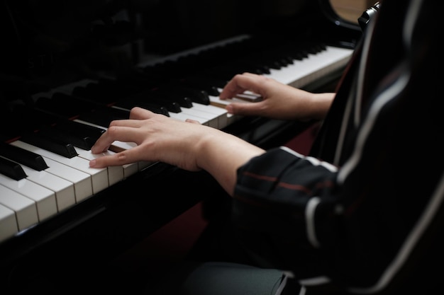 Mooie vrouw die piano speelt, leert piano spelen