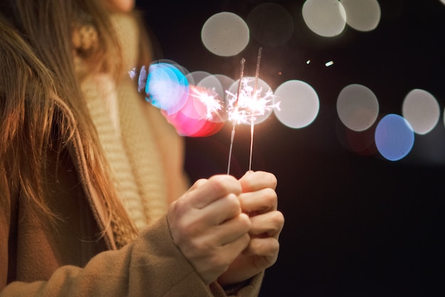 Mooie vrouw die pret, met sterretje in haar handen heeft die nieuwe jaarvooravond vieren