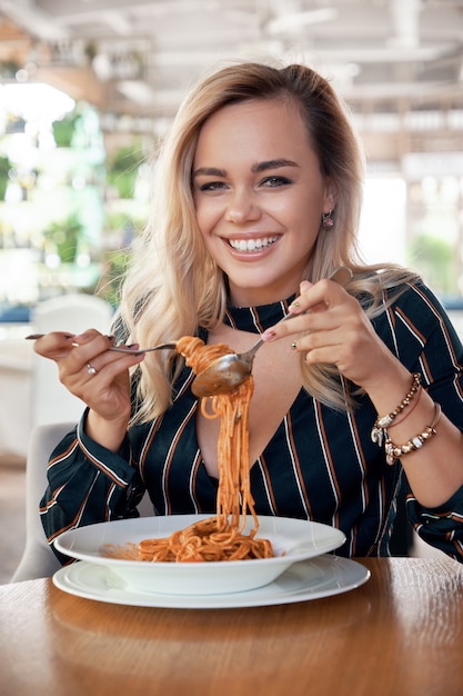 Mooie vrouw die spaghetti eet