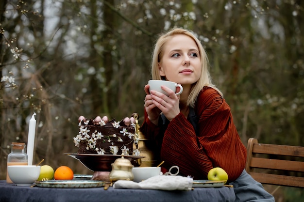 Mooie vrouw die thee drinkt in een tuin