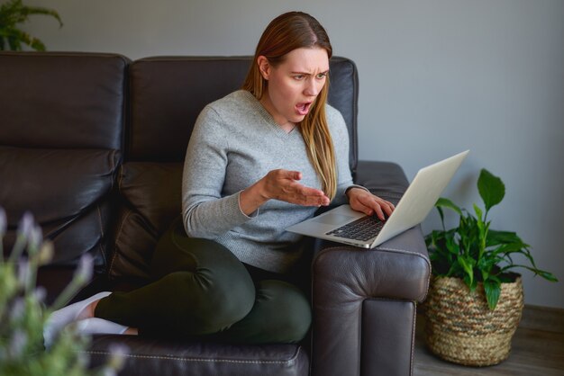 Mooie vrouw die thuis een laptop computer met behulp van