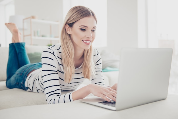 Mooie vrouw die thuis laptop met behulp van