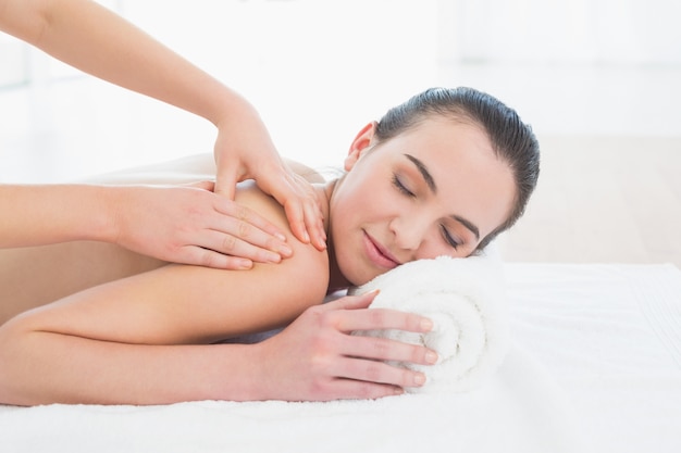 Mooie vrouw die van achtermassage geniet in beauty spa