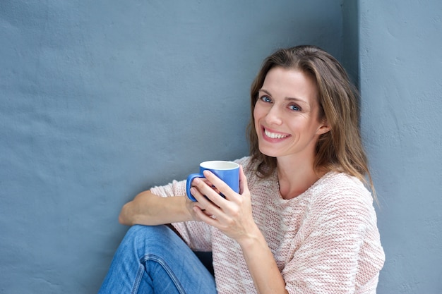 Mooie vrouw die van een drank van een koffie geniet