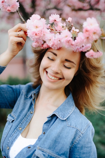 Mooie vrouw die van madeliefjegebied genieten, aardig wijfje die in weide van bloemen liggen, mooi meisje die openlucht ontspannen, pret hebben, installatie houden, gelukkige jonge dame en de lente groene aard, harmonieconcept