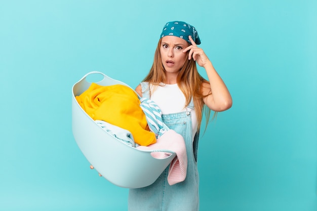 mooie vrouw die verrast kijkt, een nieuwe gedachte, idee of concept realiseert met een wasmand