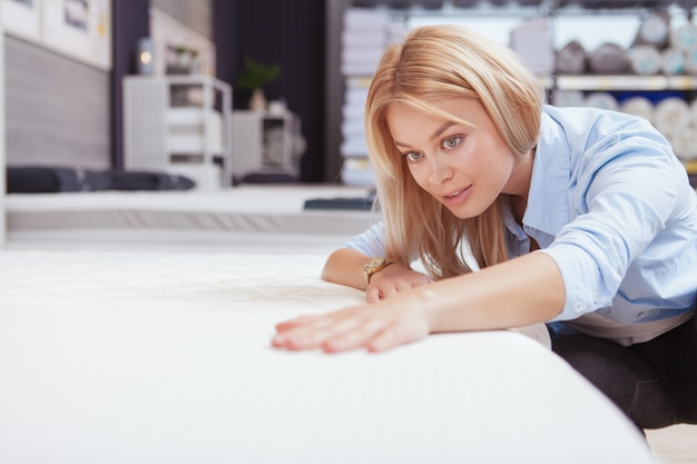 Foto mooie vrouw die voor orthopedisch matras winkelt