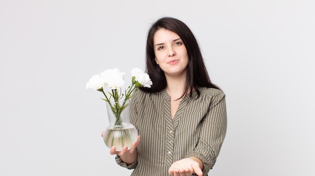 Mooie vrouw die vrolijk lacht met vriendelijk en een concept aanbiedt en toont en decoratieve bloemen vasthoudt. assistent-agent met een headset