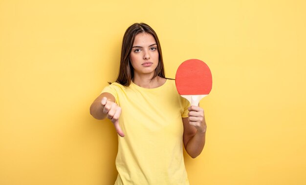 Mooie vrouw die zich boos voelt en duimen naar beneden laat zien. pingpongconcept