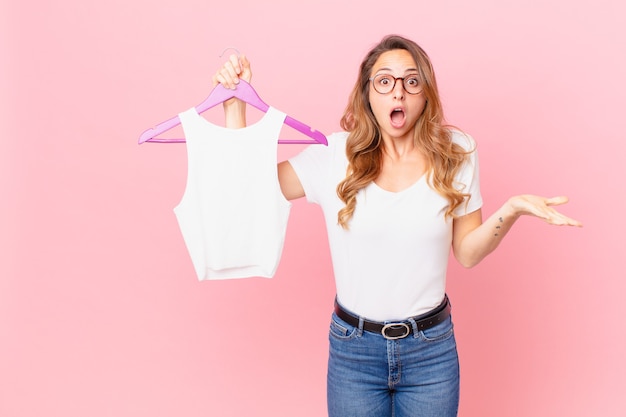 Mooie vrouw die zich extreem geschokt en verrast voelt en kleding kiest