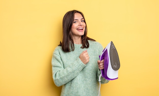 Mooie vrouw die zich gelukkig voelt en een uitdaging aangaat of het concept van ijzeren kleding viert