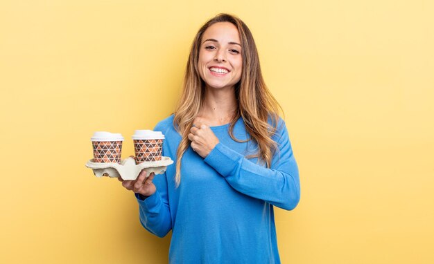 Mooie vrouw die zich gelukkig voelt en een uitdaging aangaat of viert. afhaal koffie concept