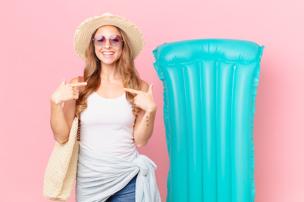 Mooie vrouw die zich gelukkig voelt en naar zichzelf wijst met een opgewonden zomer concept