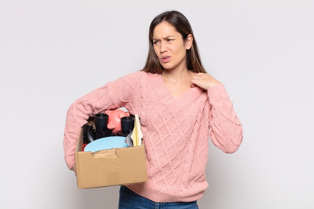 Mooie vrouw die zich gestrest, angstig, moe en gefrustreerd voelt, aan de hals van het shirt trekt, gefrustreerd kijkt door het probleem