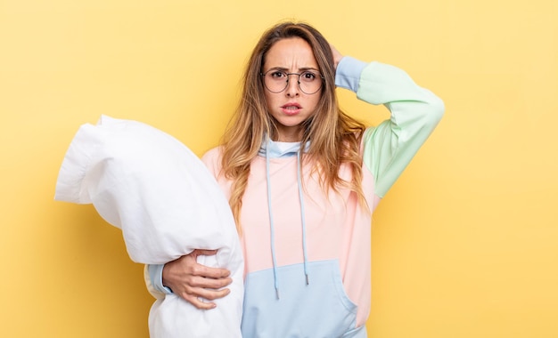 Mooie vrouw die zich gestrest, angstig of bang voelt, met de handen op het hoofd. pyjama concept