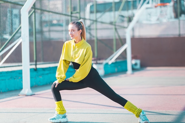 Mooie vrouw die zich uitstrekt voordat ze gaat trainen