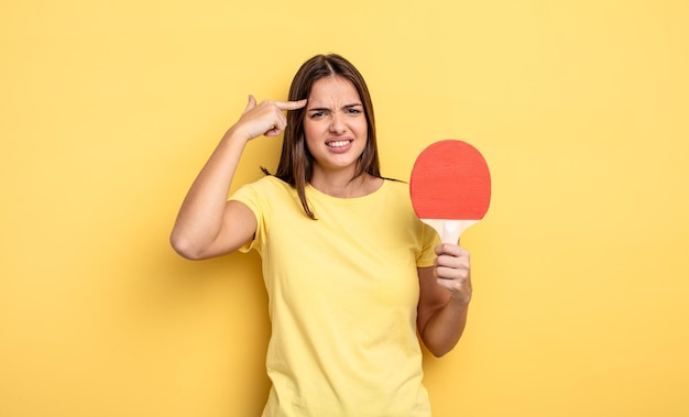 Mooie vrouw die zich verward en verbaasd voelt en laat zien dat je een krankzinnig pingpongconcept bent