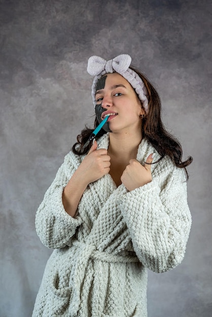 Mooie vrouw die zwart masker op haar geïsoleerd gezicht toepast