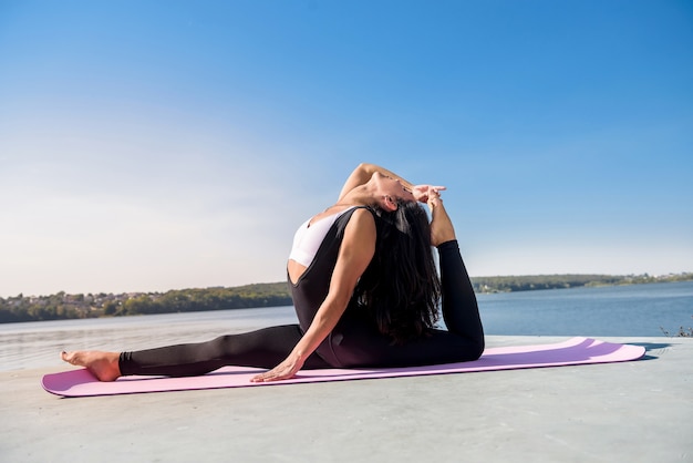 Mooie vrouw doet split op een warme zomerdag. sport actieve levensstijl concept