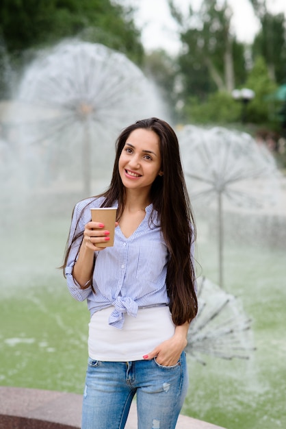 Mooie vrouw drinkt koffie in een straatcafé.